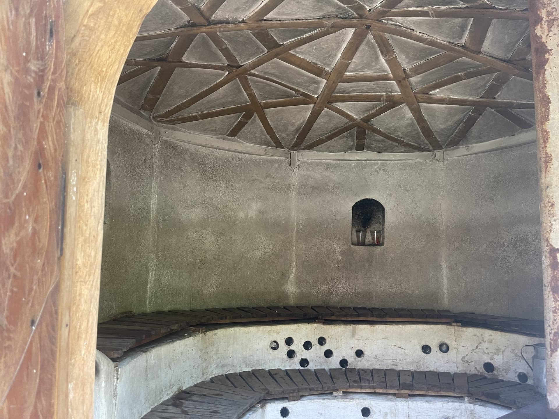 Inside the temazcal at Granja Tz’ikin — a smooth earthen dome with a star pattern worked into the ceiling and coloured glass bottles set into the wall
