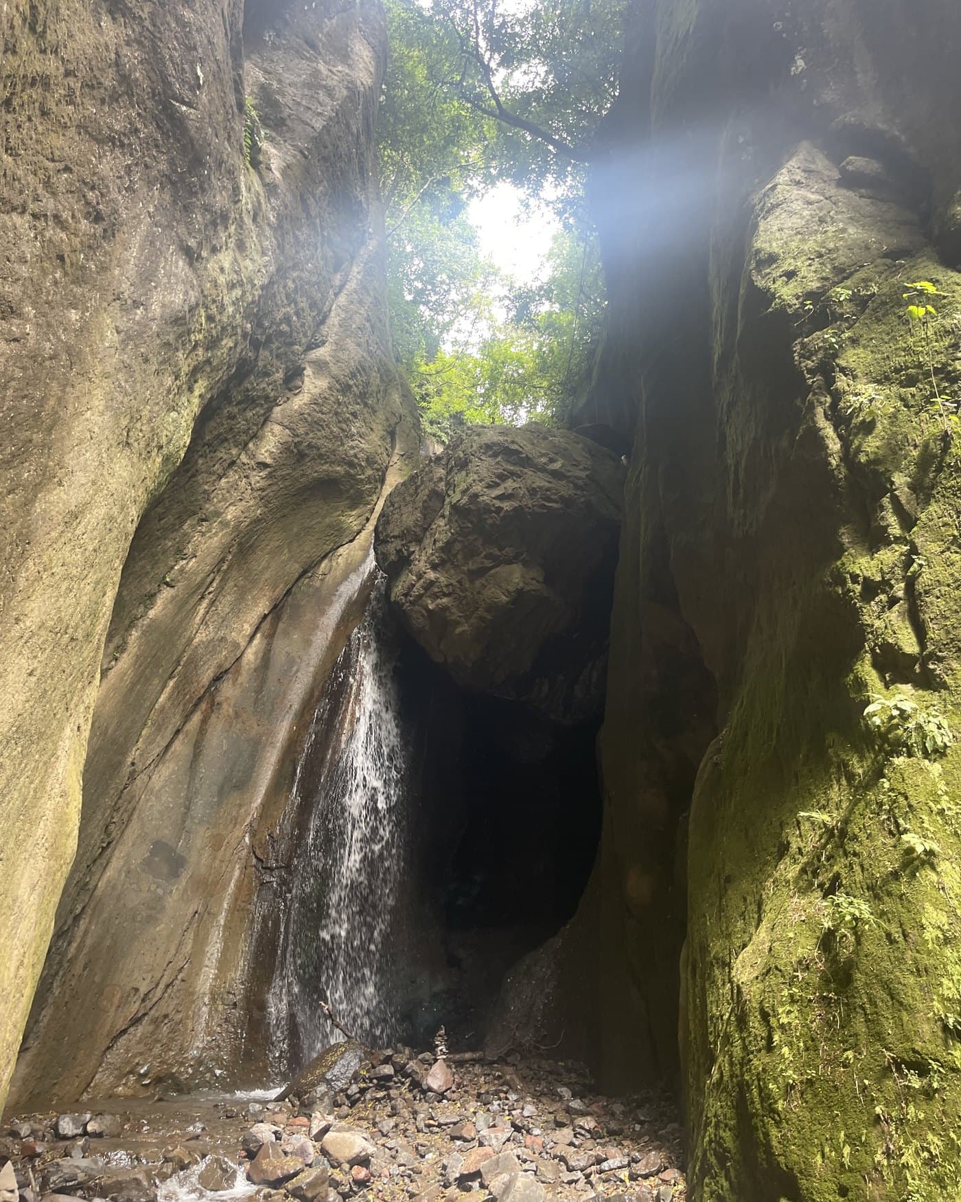 A waterfall falling between high rock walls in the canyon above Tzununá